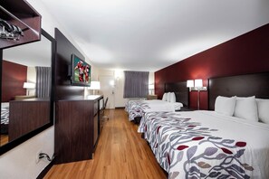 A hotel room with a large bed, a desk, a television, and a mirror. - Red Roof Inn Bordentown - McGuire AFB (Bordentown)
