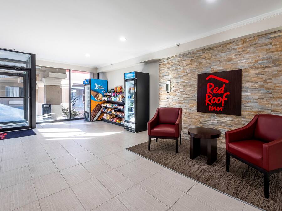 Rebost d'hotel amb un senyalitzador de Red Roof, una màquina de gelats Blue Bunny i butaques de cuir.
