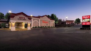 A Red Roof Inn hotel lobby with a number 1073 sign, a large Red Roof Inn sign, and a billboard advertising extended stay and meeting rooms. - Red Roof Inn Bordentown - McGuire AFB (Bordentown)