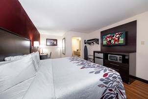 Una habitación de hotel con cama, televisión, escritorio y microondas.