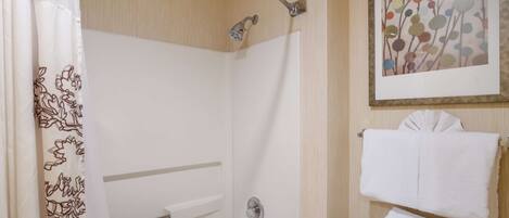A bathroom with a shower, toilet, and towel rack.