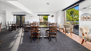 Une salle de conférence dotée d’une longue table et de chaises, de grandes fenêtres et offrant une vue sur la verdure.