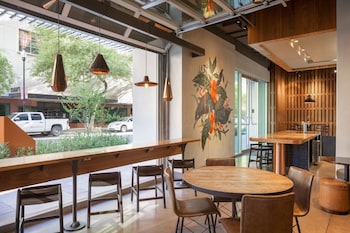 A modern lobby with a circular reception desk, a hanging light fixture, and a patterned wall. at Renaissance Phoenix Downtown Hotel