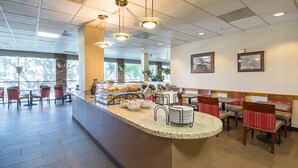 A breakfast bar with seating and a view of the outdoors. - Comfort Inn by the Bay (San Francisco)