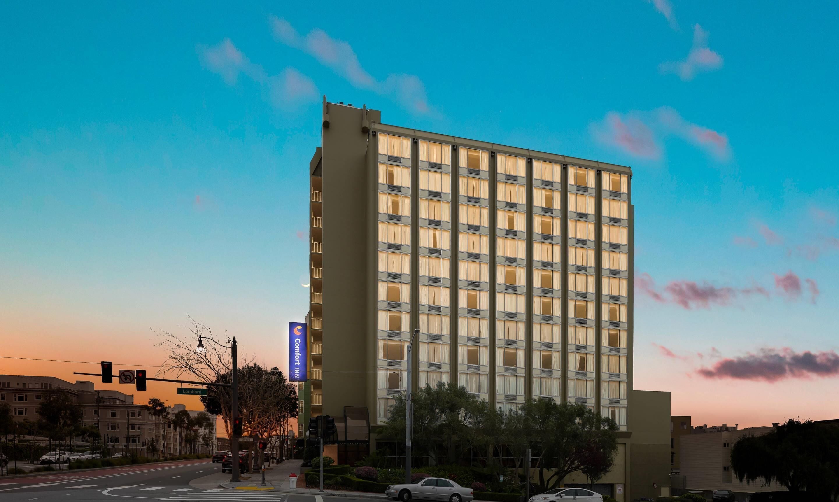 A tall hotel with a modern facade, large windows, and a prominent sign indicating it is a Comfort Inn.