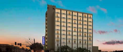 A tall hotel with a modern facade, large windows, and a prominent sign indicating it is a Comfort Inn.