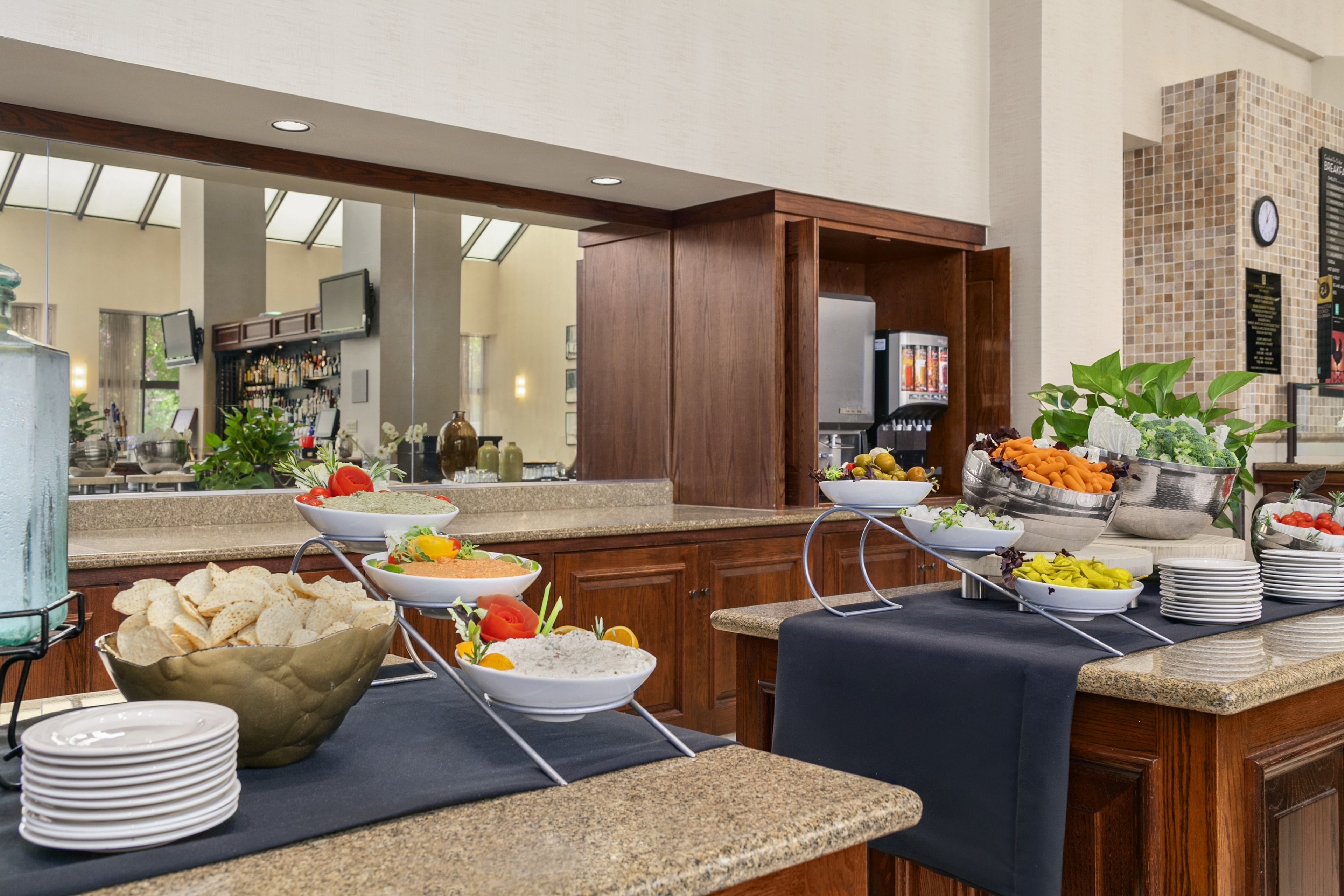 A buffet setup with various food items and a clock on the wall.