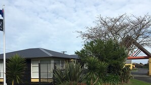 A residential property with a well-maintained lawn, a variety of shrubs, and a flagpole.