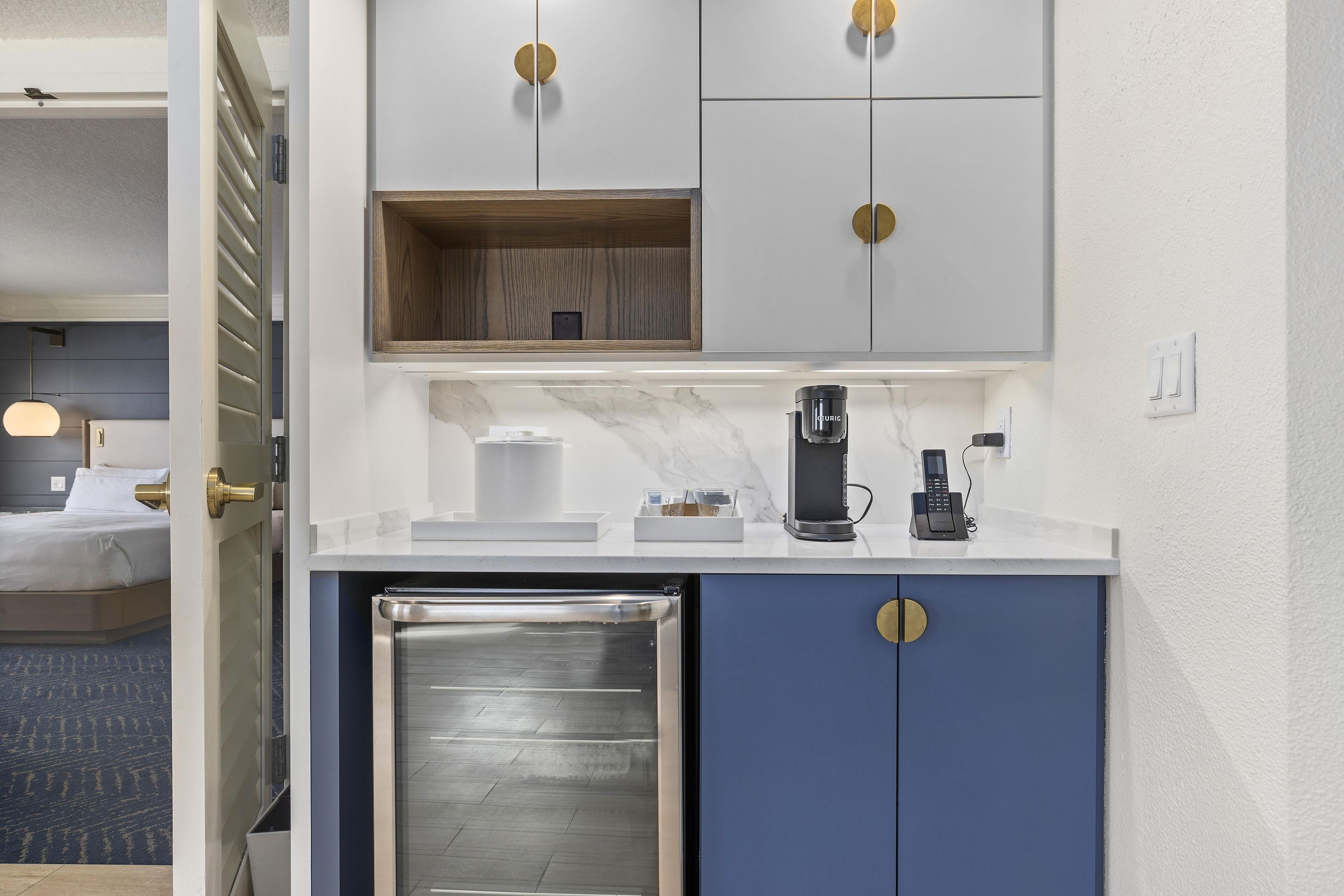 A compact kitchenette with a coffee maker, a mini-fridge, and a microwave.