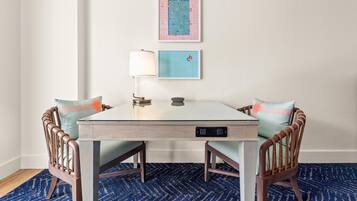 A small dining area with a table, chairs, and two wall-mounted artworks.