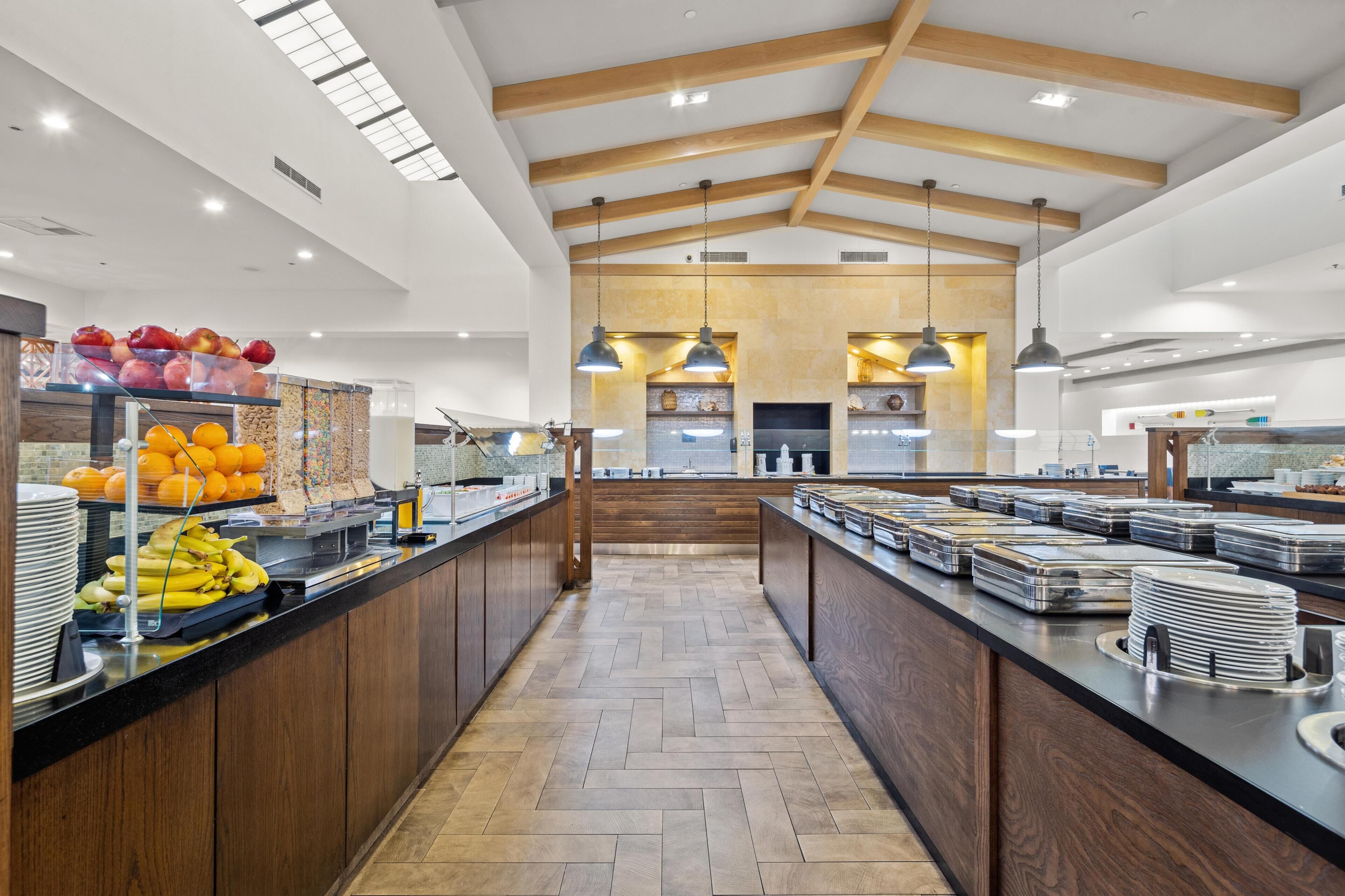 Een moderne keuken met houten balken, een visgraatvloer en een centraal kookeiland met etenswaren.