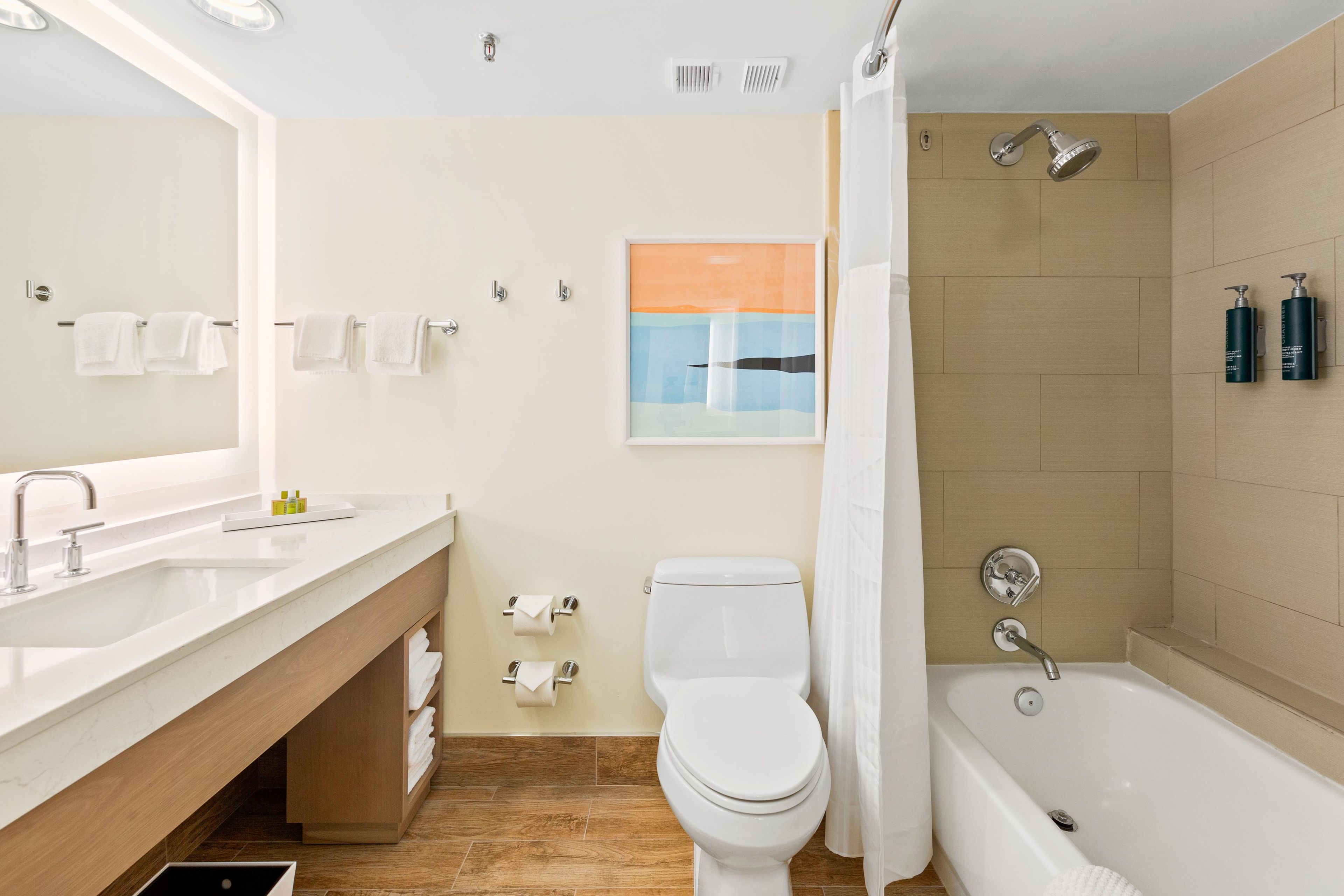A modern bathroom with a sink, toilet, and bathtub.