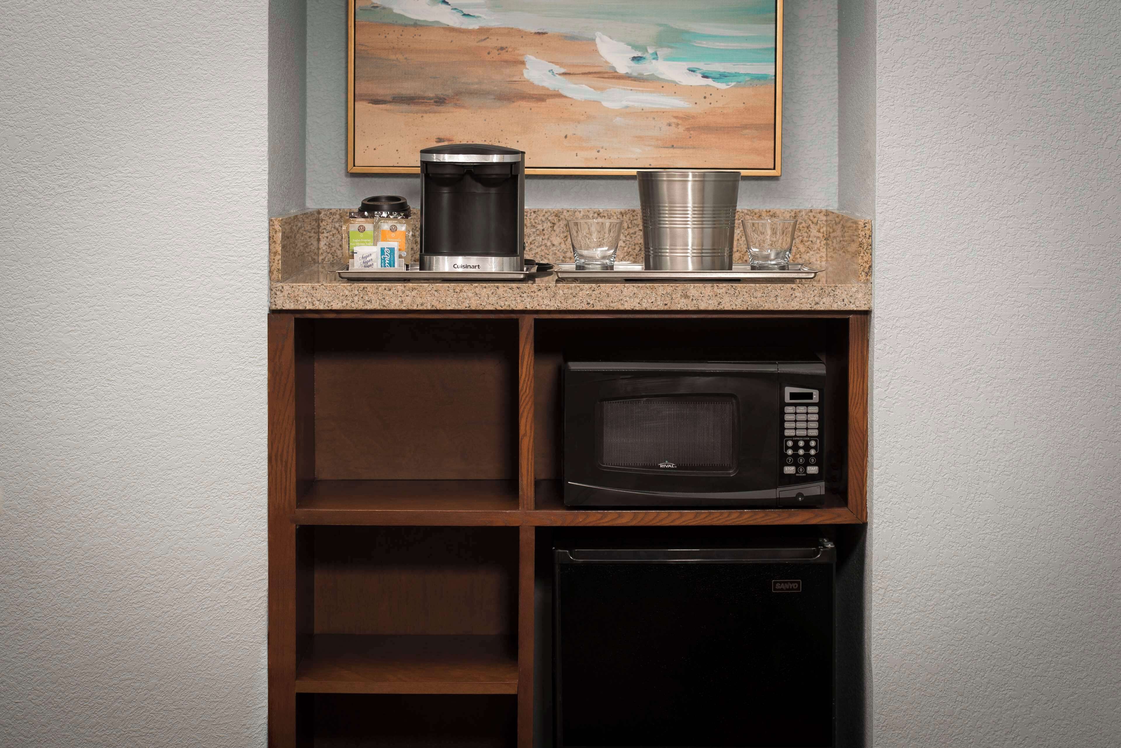 Una kitchenette equipada con cafetera, microondas y refrigerador.