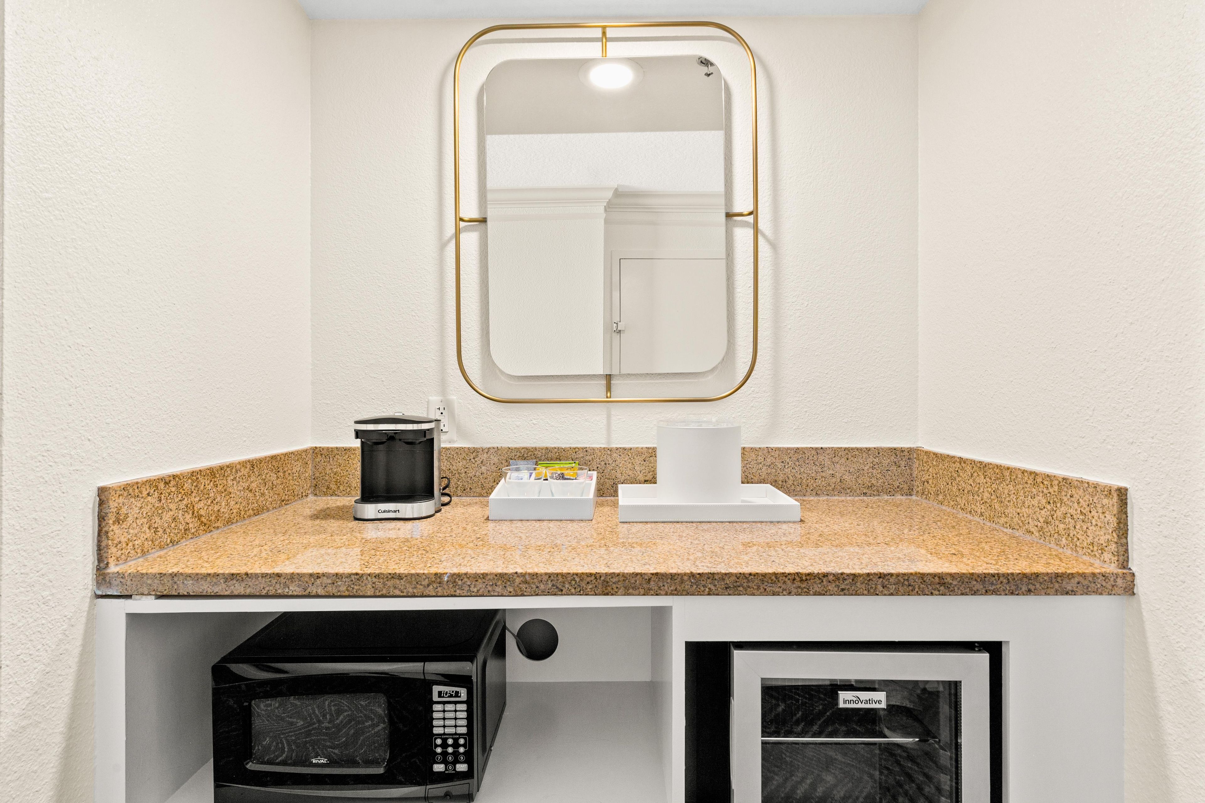 A kitchenette with a coffee maker, a microwave, and a small refrigerator.