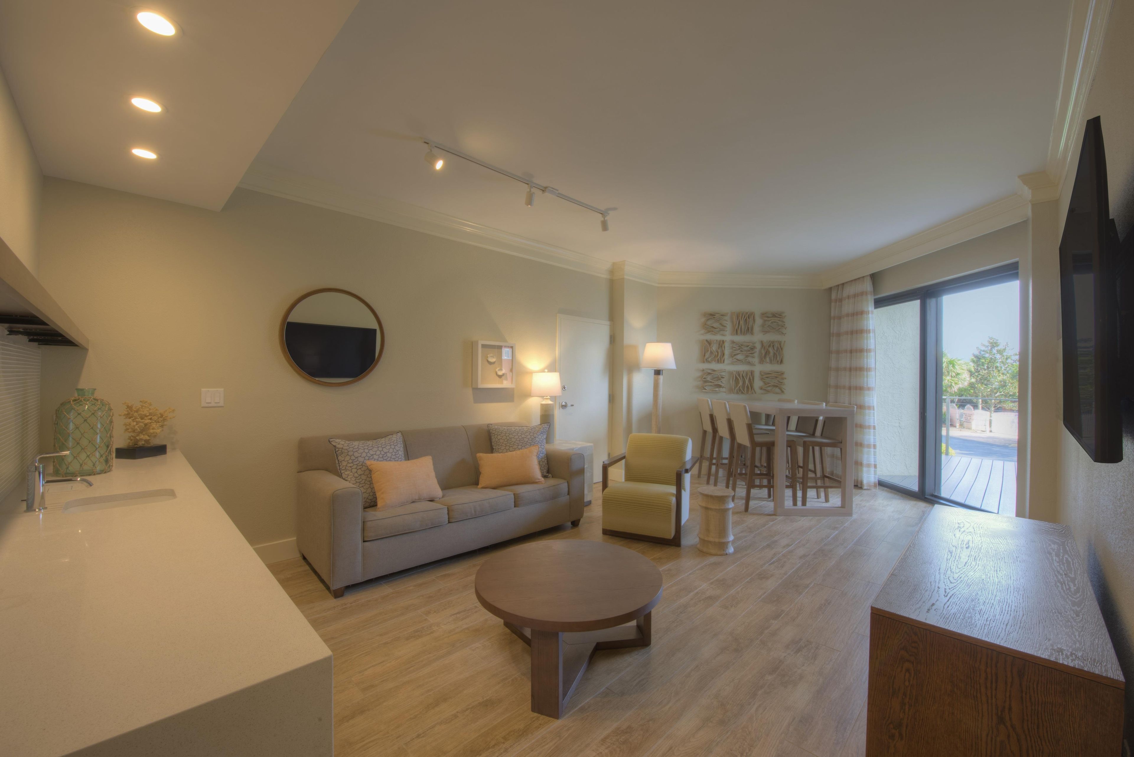 A modern living room with a sofa, coffee table, and dining area.