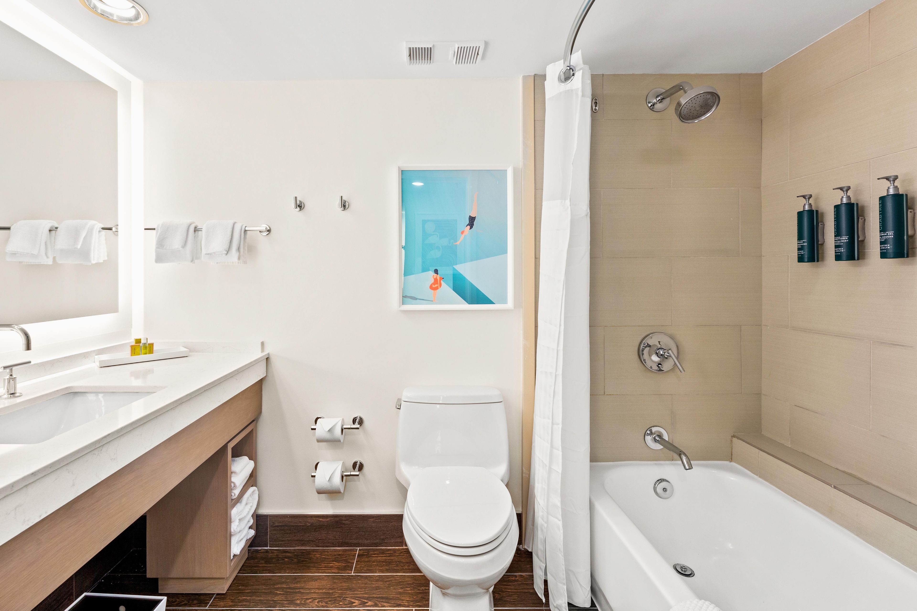 A modern bathroom with a bathtub, toilet, and sink.