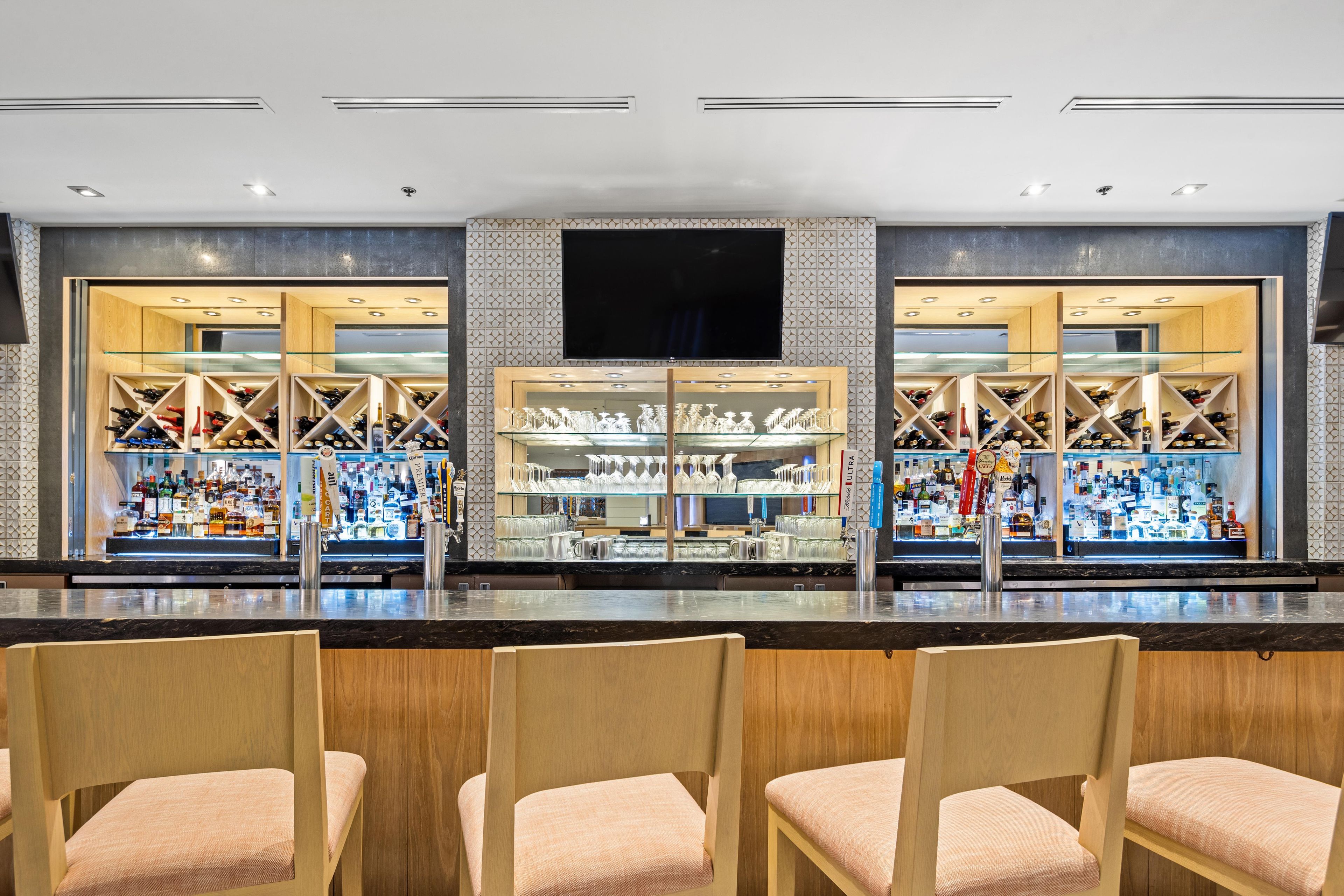 A bar area with seating and a television screen above the bar.