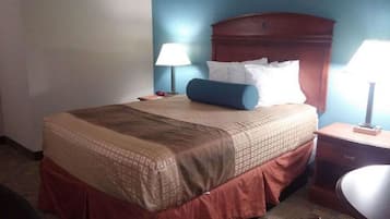 A hotel room with a bed, two bedside lamps, a nightstand, and a chair.