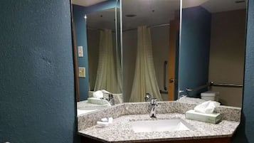 Une salle de bain avec un lavabo en granit, un miroir et un rideau de douche.