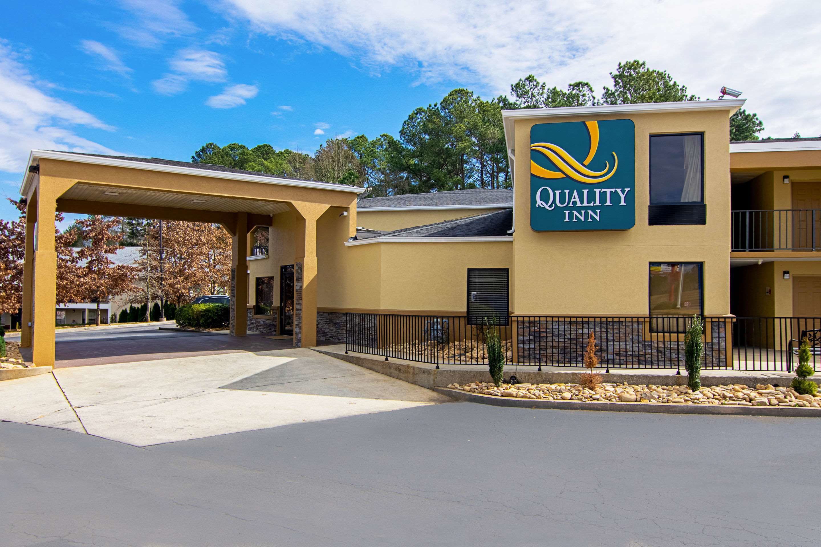A Quality Inn with a covered entrance, a signboard, and a building with balconies.