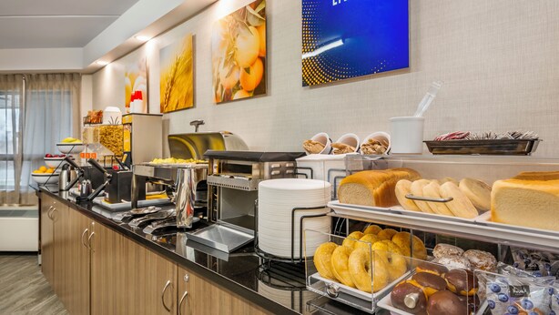 Un bufé con diferentes opciones de comida y una estación de café.