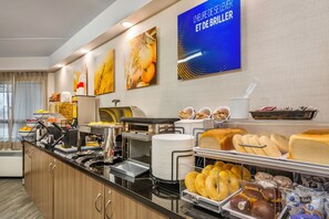 A buffet with various food items and a coffee station.