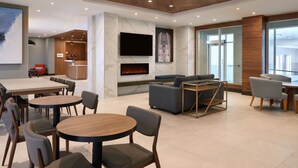 A modern interior with a fireplace, seating areas, and a bar. - Fairfield by Marriott Niagara Falls, Canada (Niagara Falls)