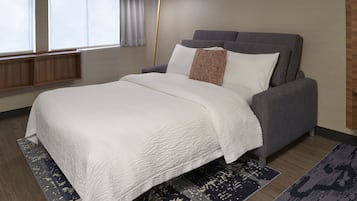 A modern bedroom with a bed, a floor lamp, and a window with curtains.