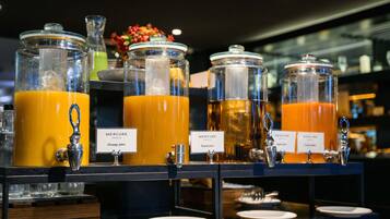 Ein Saftbar mit Spendern, auf denen 'Orangensaft', 'Pfirsichsaft' und 'Apfelsaft' stehen.