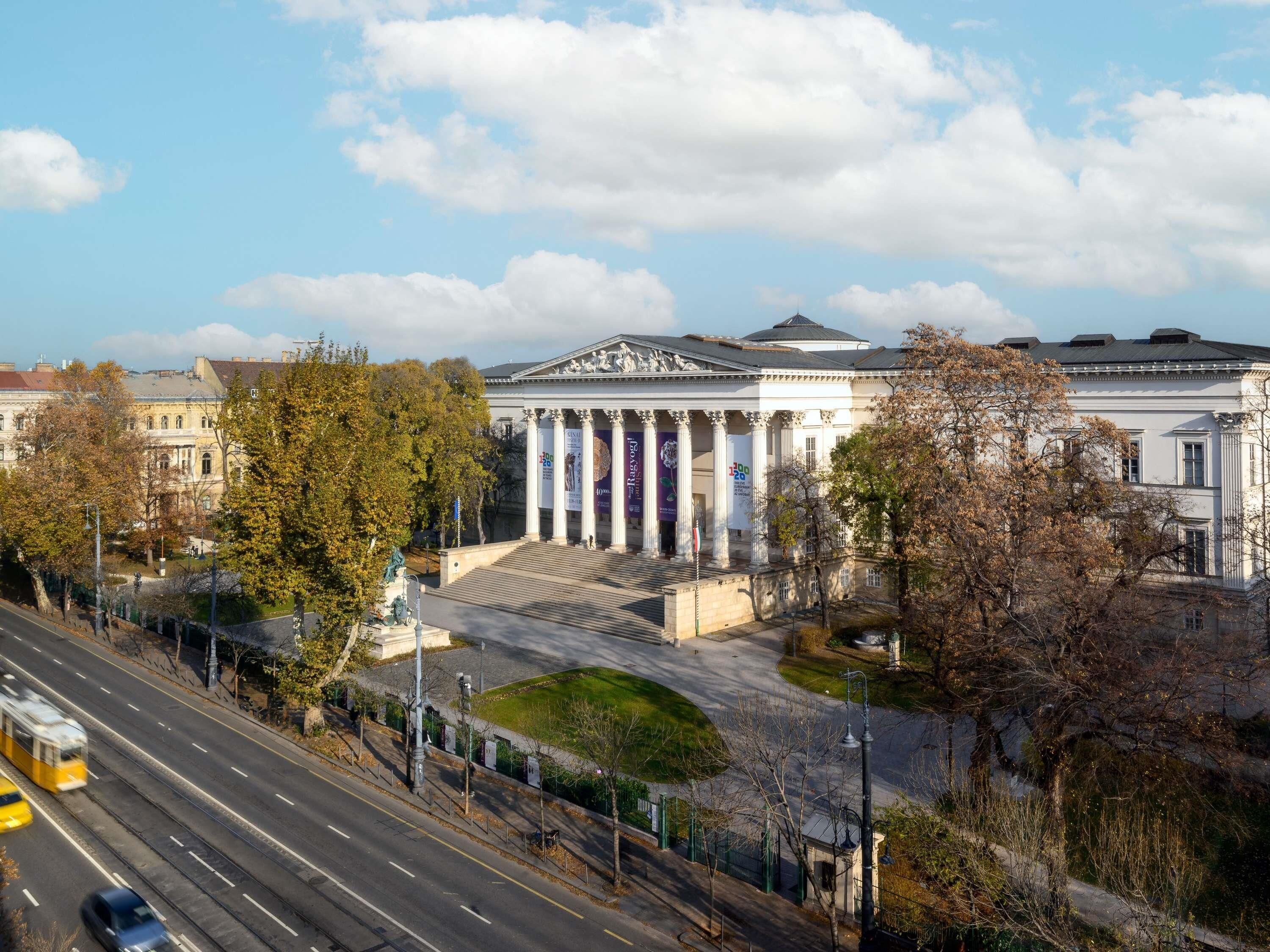 Ένα κλασικό κτίριο με κολόνες, έναν θόλο και ένα άγαλμα μπροστά.