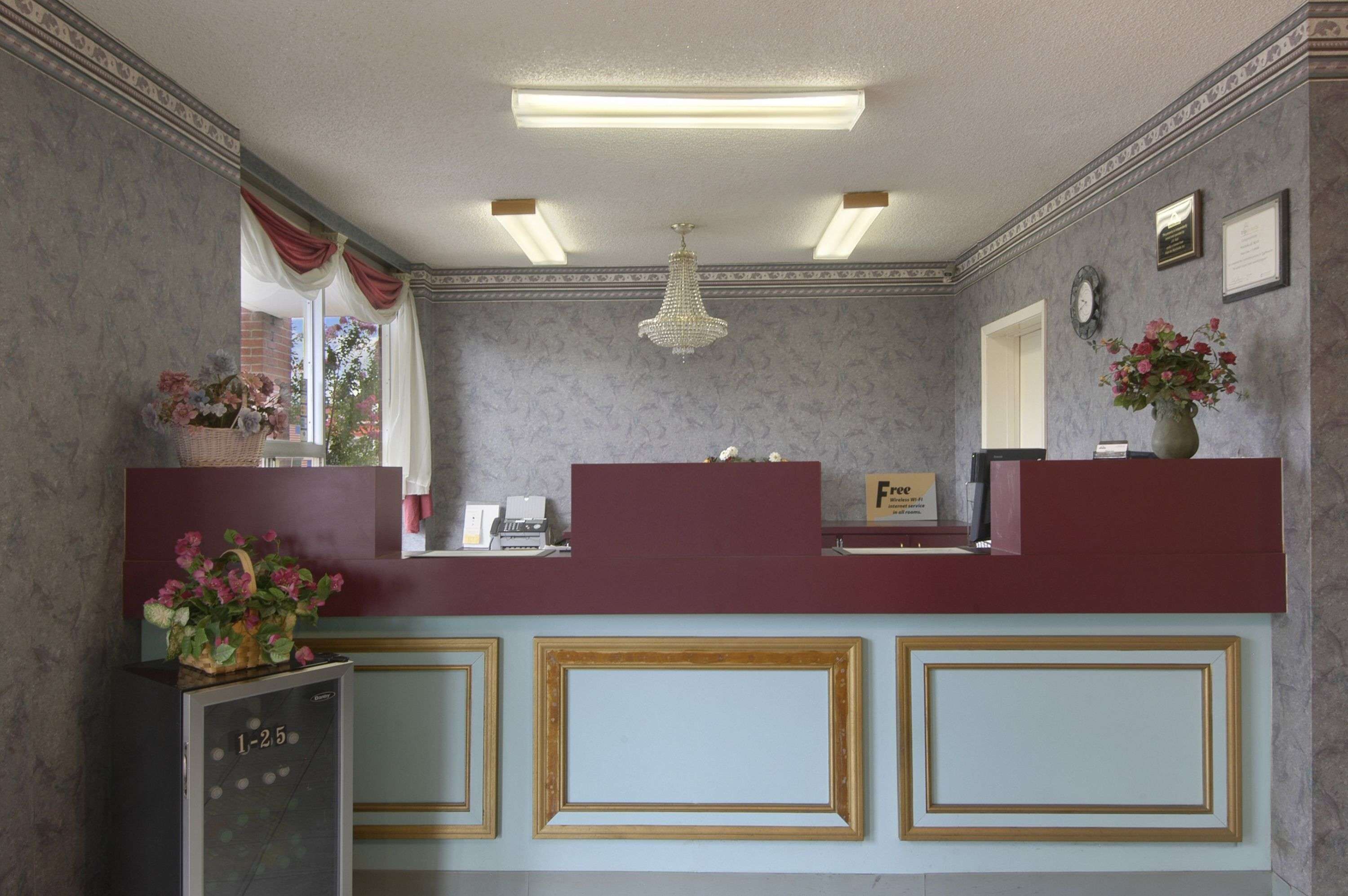 A reception area with marble walls, a chandelier, and framed artwork.