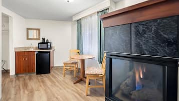 A compact living space with a kitchenette, a dining area, and a fireplace.