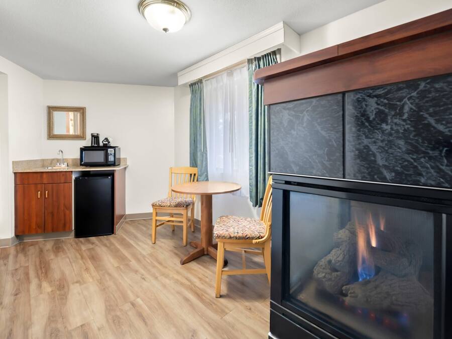 A compact living space with a kitchenette, a dining area, and a fireplace.