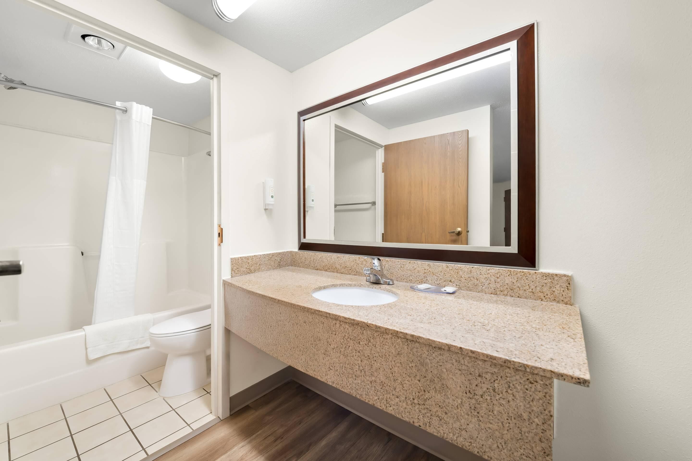 Une salle de bain avec un lavabo, un miroir et une douche.