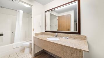 Une salle de bain avec un lavabo, un miroir et une douche.
