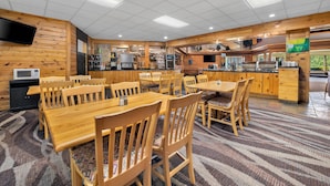 Un restaurant aux murs en bois, au plafond carrelé et doté d’un bar central.