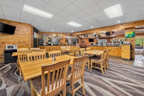 A restaurant with wooden walls, a tiled ceiling, and a central bar area. - Quality Inn & Suites Black River Falls I-94 (Black River Falls)