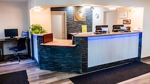 A reception desk with a stone facade, a computer monitor, and a plant. - Comfort Inn Kennewick Richland (Kennewick)