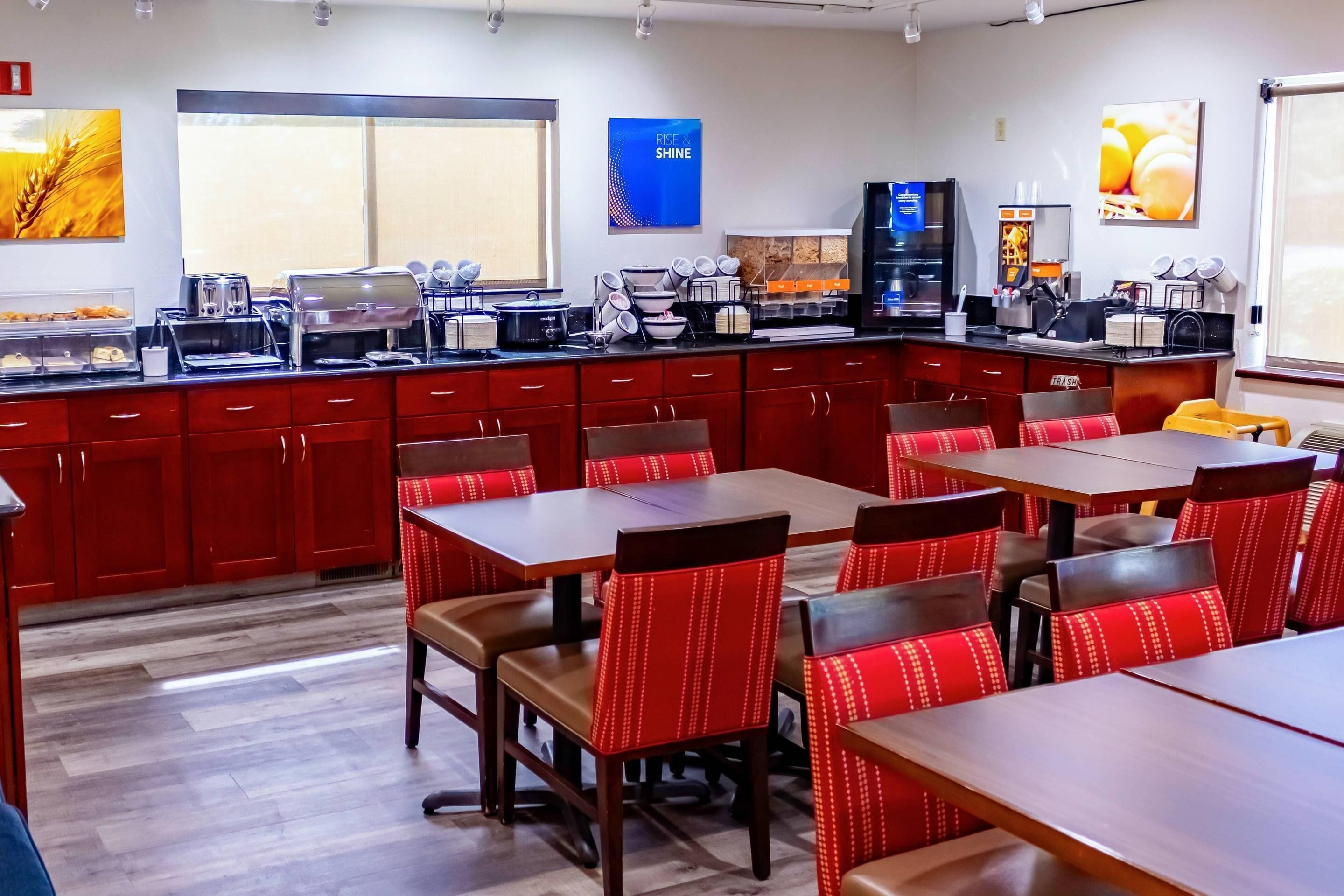 Un restaurante con mostrador, cabinas rojas y zona de cocina.