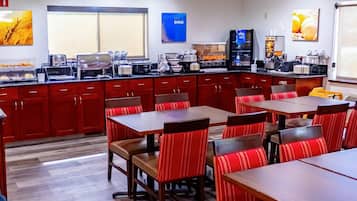 Un restaurante con mostrador, cabinas rojas y zona de cocina.