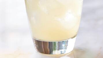 Un verre de boisson glacée, garni d’une tranche de concombre et muni d’une paille.