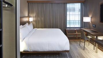 Una habitación de hotel moderna con una cama grande, un escritorio y una televisión.