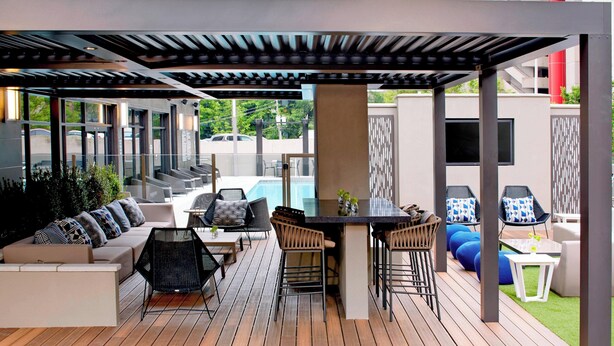 A modern outdoor patio with a pool, seating areas, and a bar. - AC Hotel by Marriott Atlanta Downtown (Atlanta)