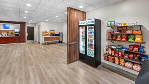 A clean, modern interior with a refrigerated display, snack shelves, and a wooden partition.