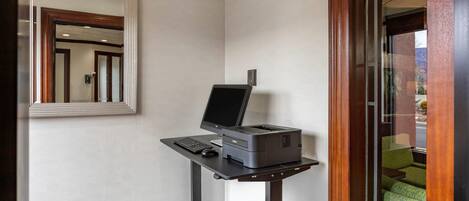 A corner desk with a computer, printer, and keyboard.