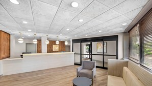 A reception area with a counter, seating, and a patterned ceiling.