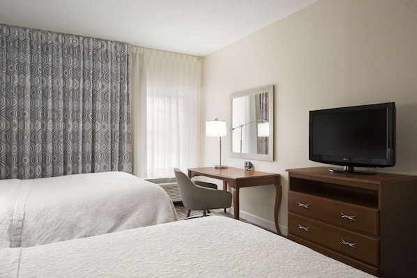 A hotel room with two beds, a desk, a chair, a TV, and a dresser. - Hampton Inn Findlay (Findlay)