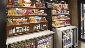 Una presentación de aperitivos con varias marcas y un refrigerador para bebidas.
