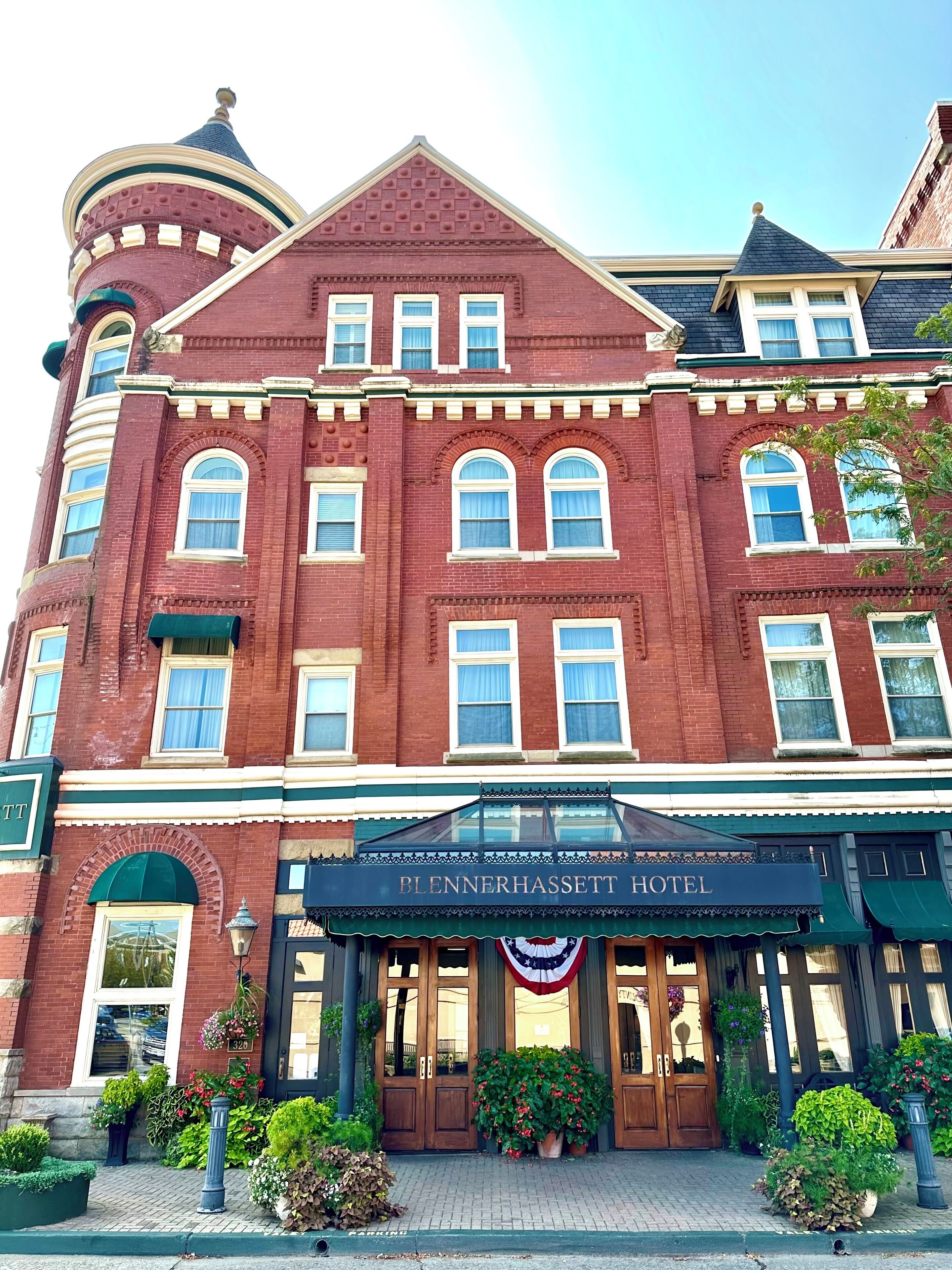 Ein historisches Hotel mit einem markanten Eingang, großen Fenstern und einem verzierten Vordach.