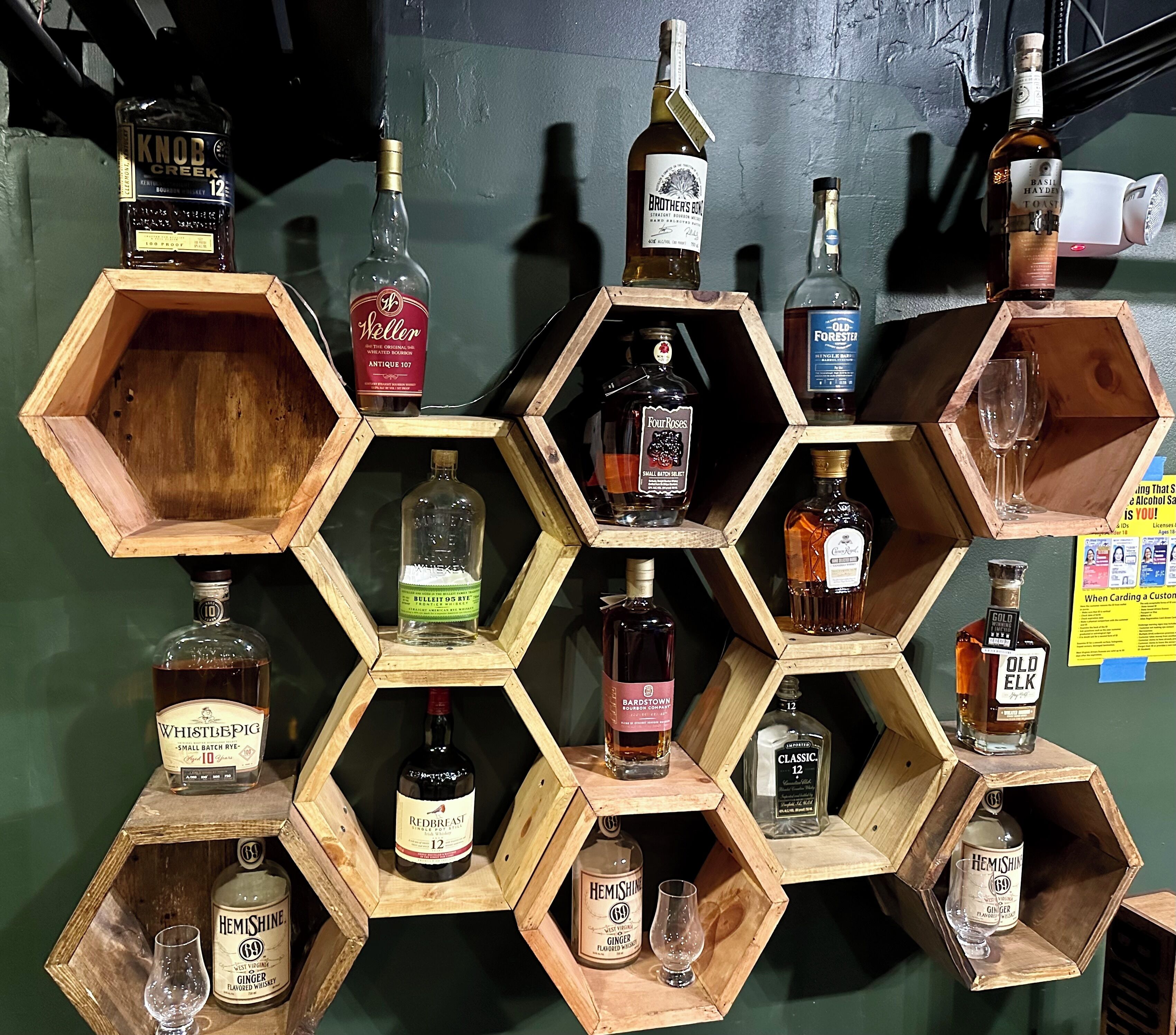 Eine sechseckige Holzwirtschaft mit verschiedenen Whiskeyflaschen.